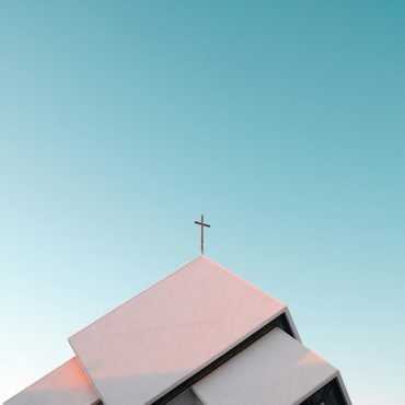 White church roof with a cross against a blue sky