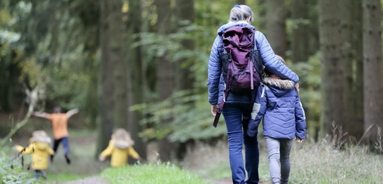 Adult and children walking along a forest path