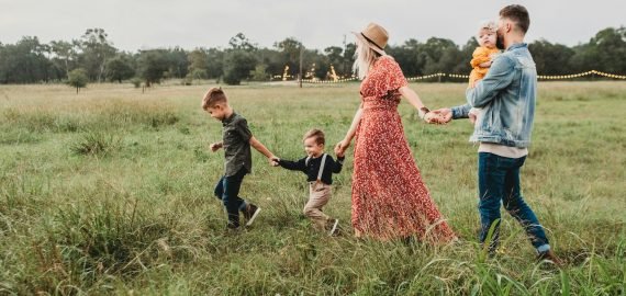 Family holding hands with a toddler