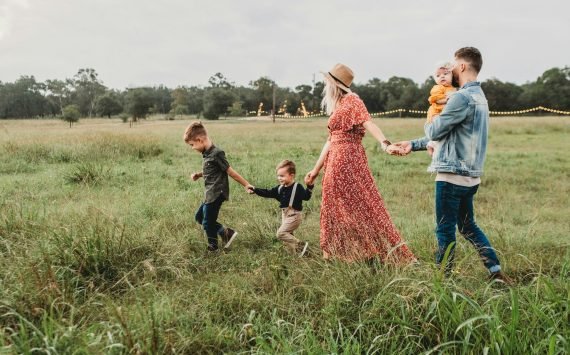 Family holding hands with a toddler