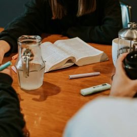 Group of people sitting around a wooden table