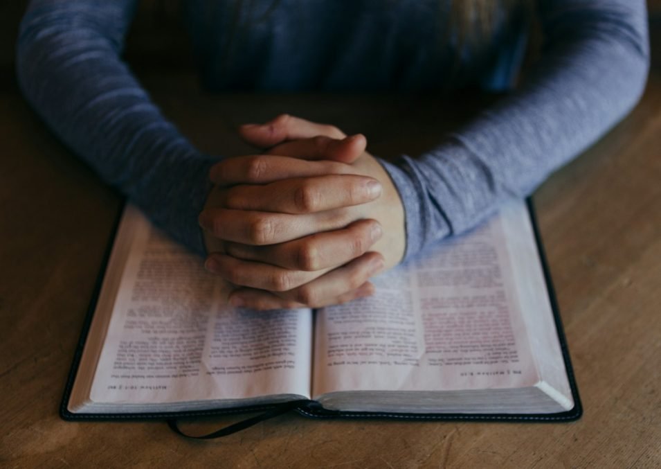 Hands resting on an open Bible